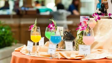 A table with three drinks labeled 'Empress Paradise' and 'Pink Cooler', each with a floral garnish.