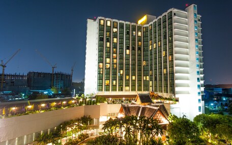 A modern hotel with a prominent corner entrance, multiple floors, and a rooftop terrace.