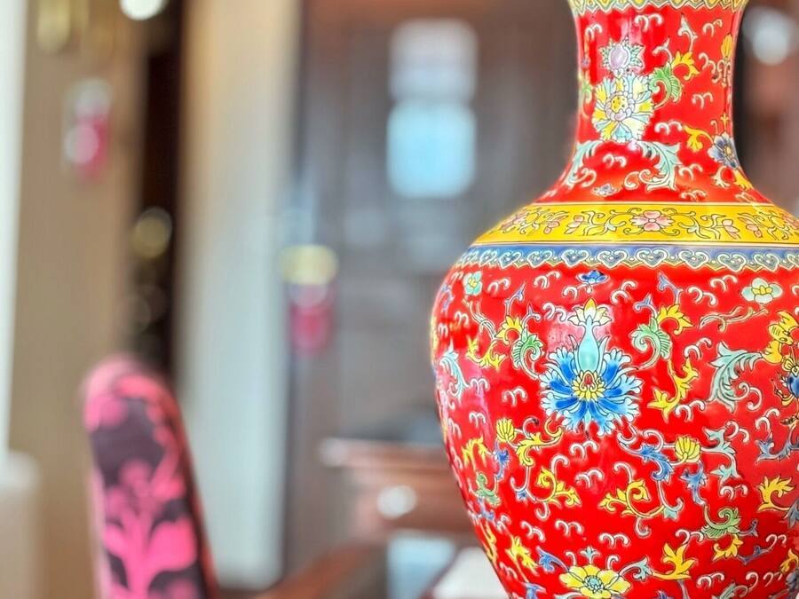 Un jarrón rojo con motivos florales.