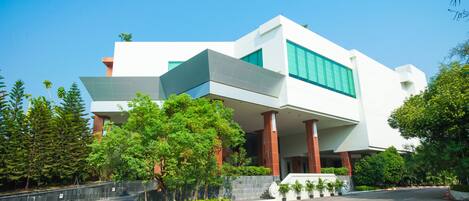 A modern building with a flat roof, large windows, and a prominent entrance.