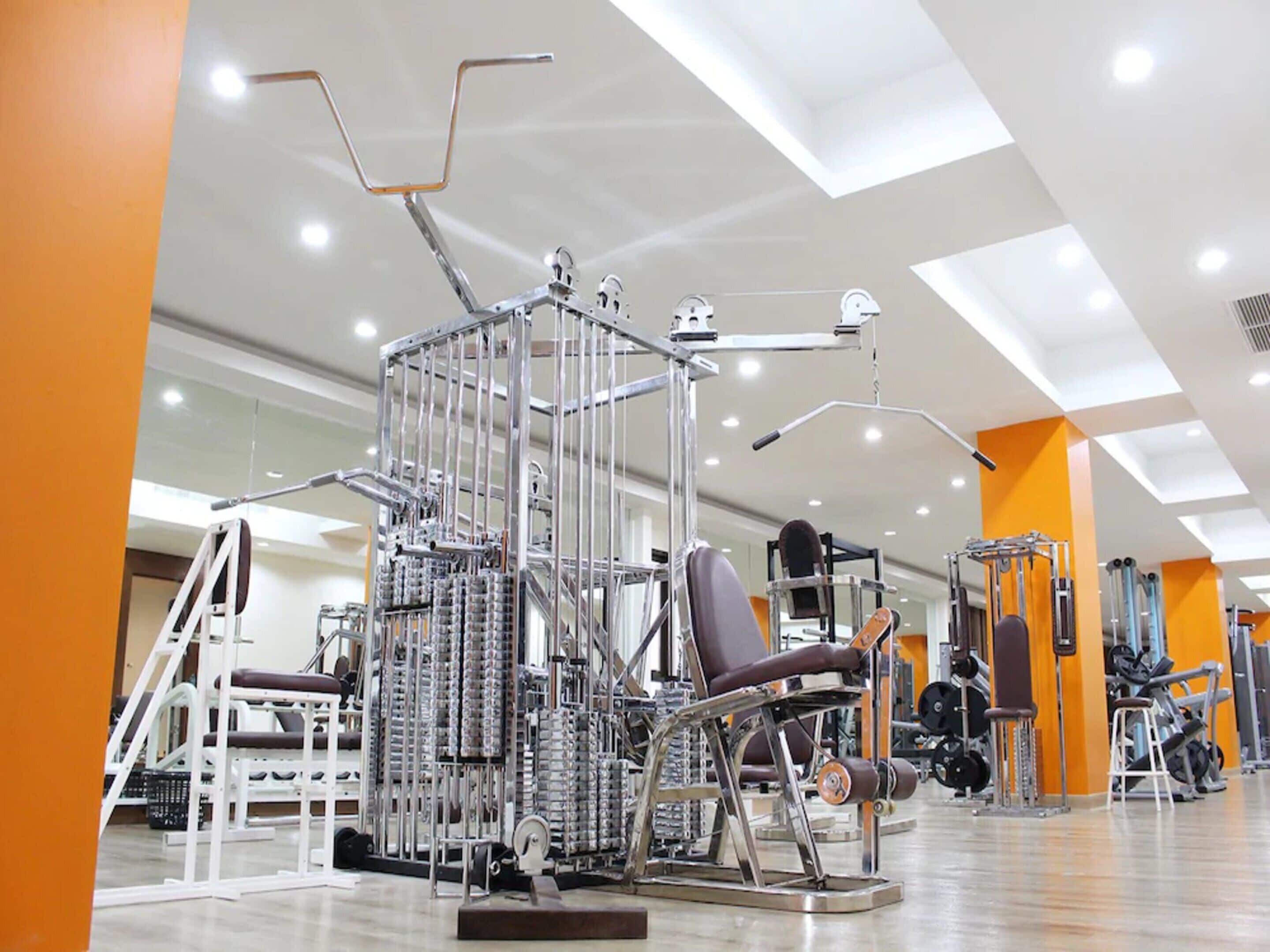 A gym with various exercise machines, including a leg press and a chest press.