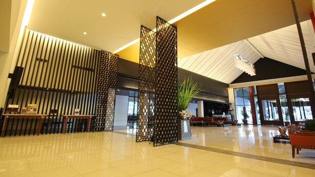 A spacious lobby with a modern design, featuring a reception desk, seating area, and decorative panels. - Chiang Mai Hill (Chiang Mai)