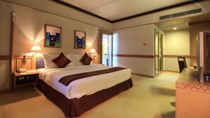 A hotel room with a large bed, two bedside lamps, a desk with a telephone, and a mirror. - Chiang Mai Hill (Chiang Mai)