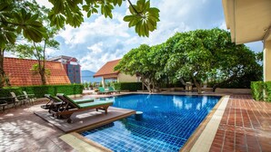 A swimming pool with lounge chairs and a tiled deck. - Chiangmai Grandview Hotel & Convention Center (Chiang Mai)