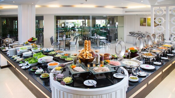 A buffet with a variety of food items, including salads, meats, and desserts, arranged on a long counter. - Chiangmai Grandview Hotel & Convention Center (Chiang Mai)