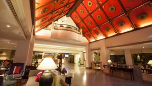 A spacious lobby with a high ceiling featuring geometric patterns, comfortable seating areas, and a reception desk. - Chiangmai Grandview Hotel & Convention Center (Chiang Mai)