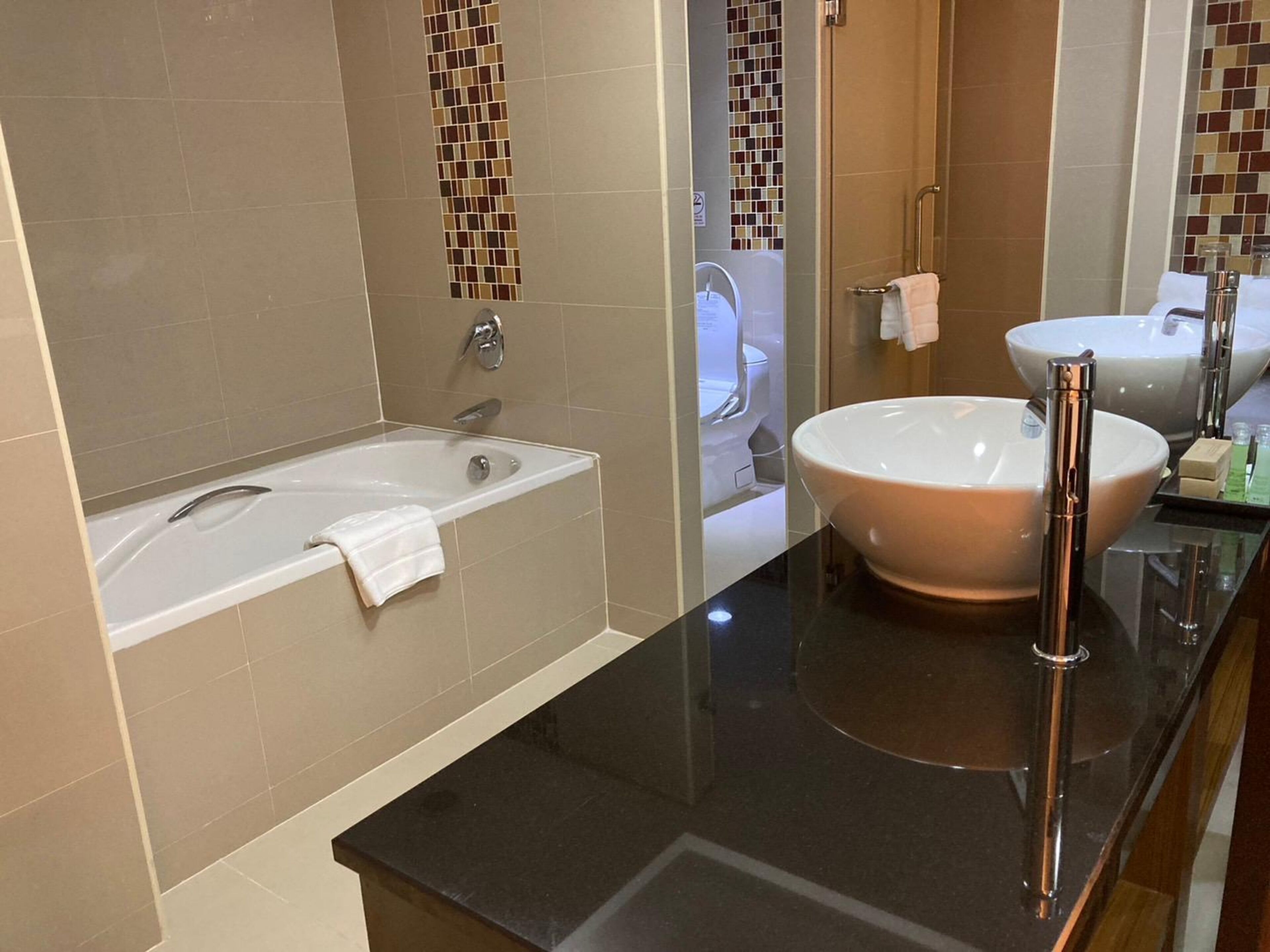 Un baño moderno con bañera, un lavabo grande y un espejo.