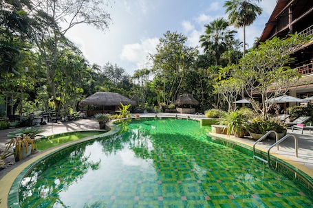Una piscina al aire libre, sombrillas, sillones reclinables de piscina. River Kwai Resotel