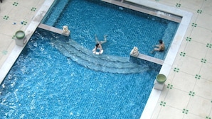 Uma piscina retangular com borda e piso revestidos em azulejo.
