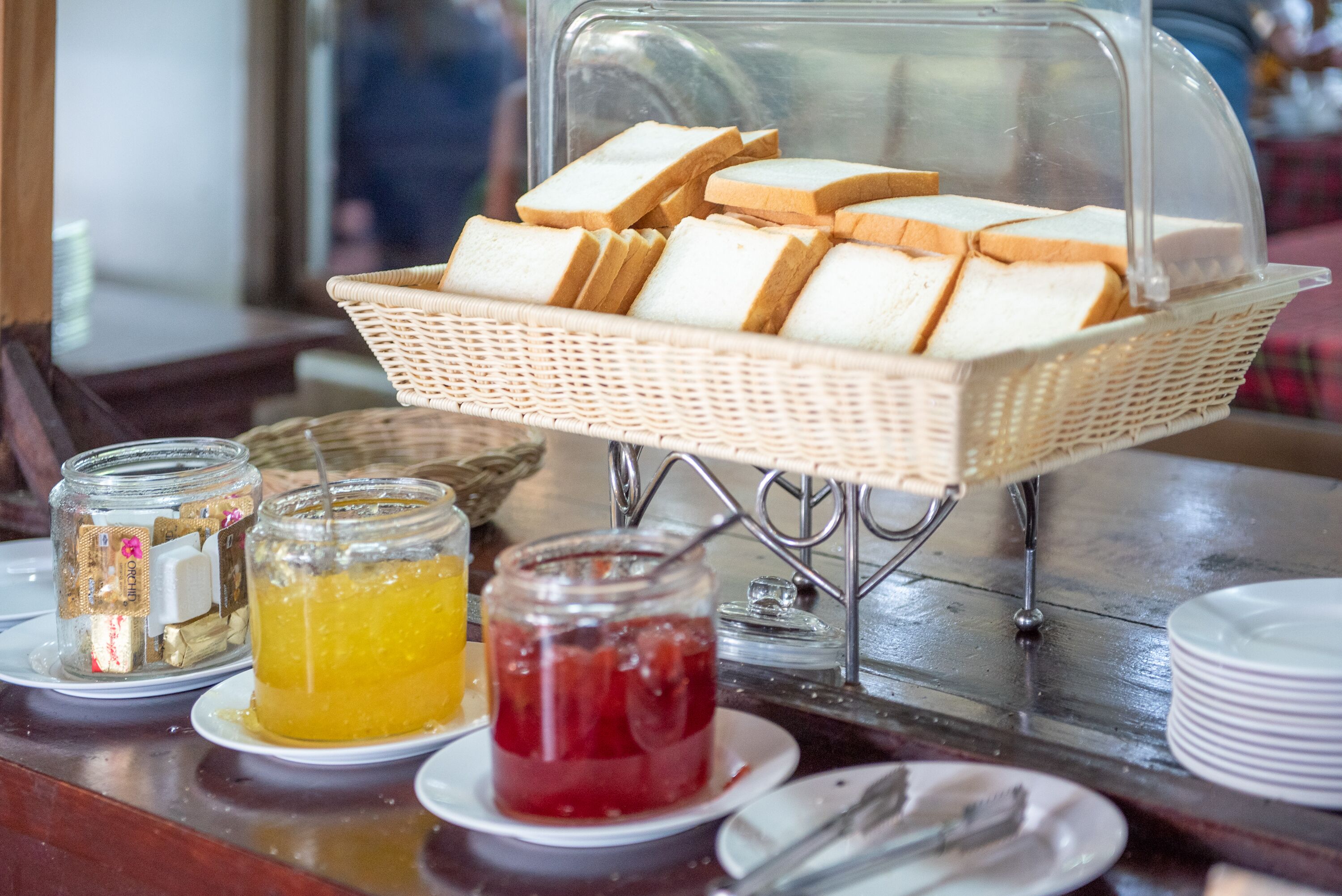 A breakfast buffet with bread, jams, and honey.