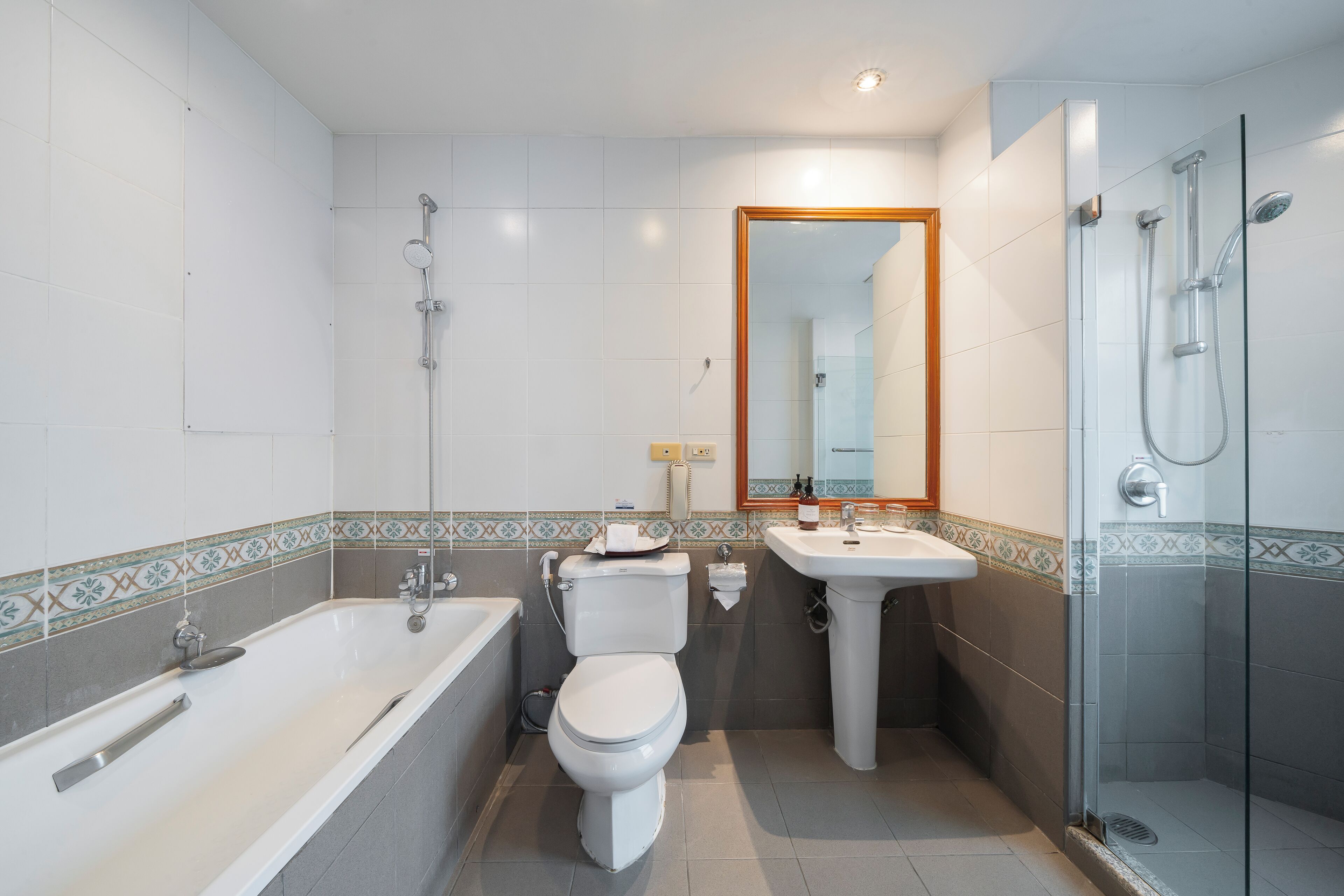 A modern bathroom with a bathtub, toilet, sink, and glass-enclosed shower.