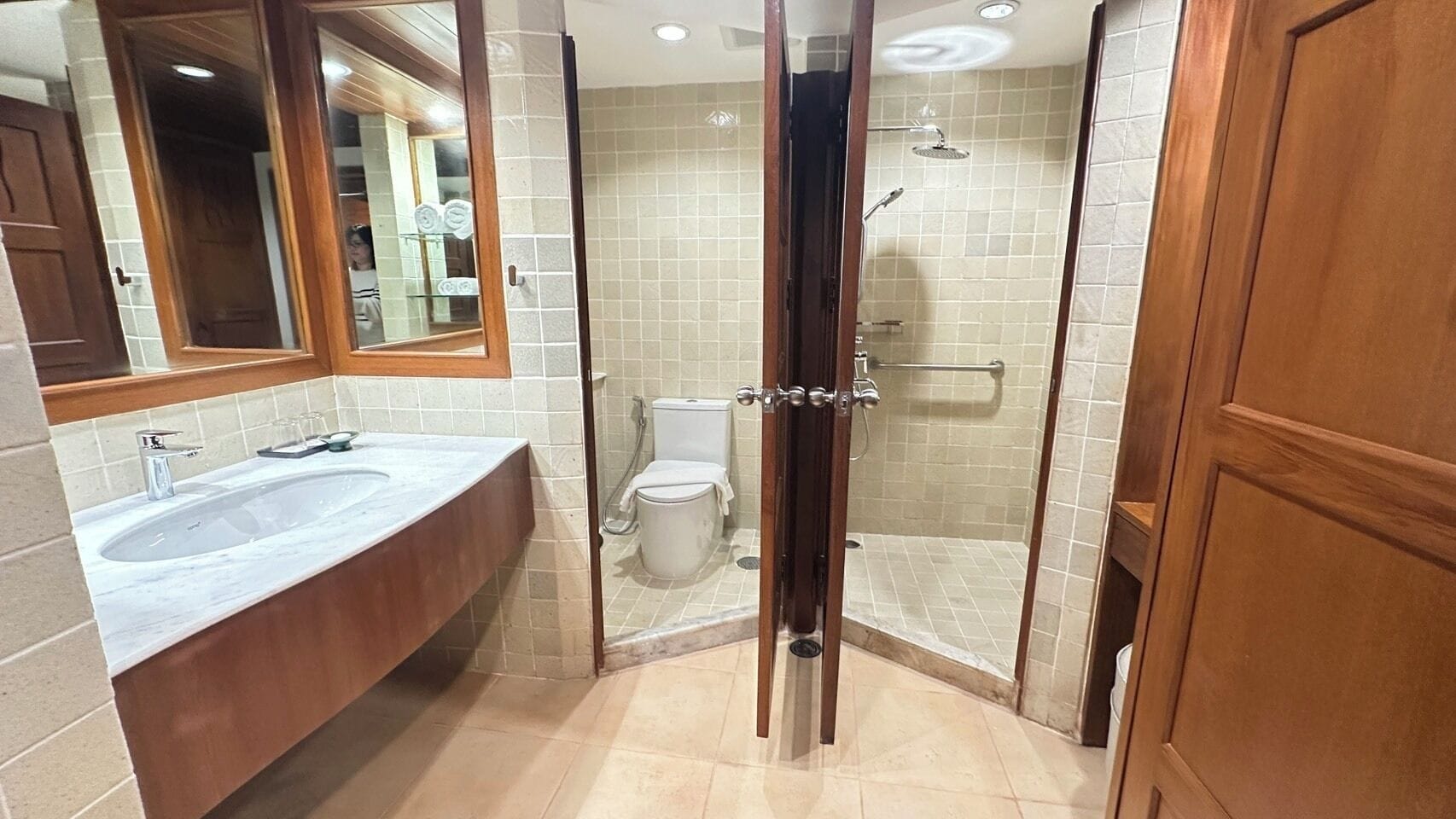 A bathroom with two sinks, a toilet, and a glass-enclosed shower area.