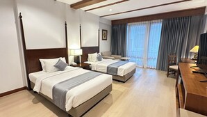 Ein Hotelzimmer mit zwei Betten, einem Schreibtisch und einem Stuhl.
