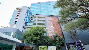 Um hotel com design moderno, exibindo uma placa chamativa para 'The Four Wings Hotel Bangkok'.