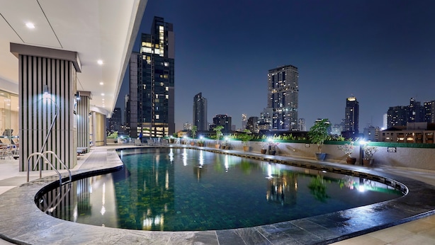 Piscina interior moderna com vista para a paisagem urbana à noite.