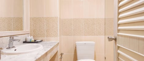 A bathroom with a toilet, a sink, and a shower.