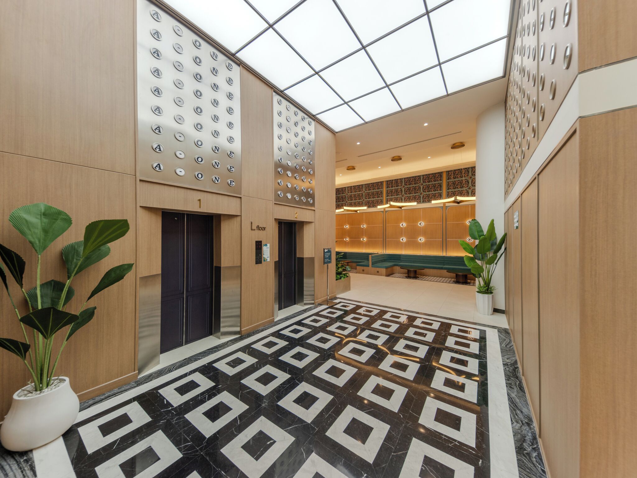 A modern lobby with a geometric patterned floor, elevators, and a seating area with a patterned wall.
