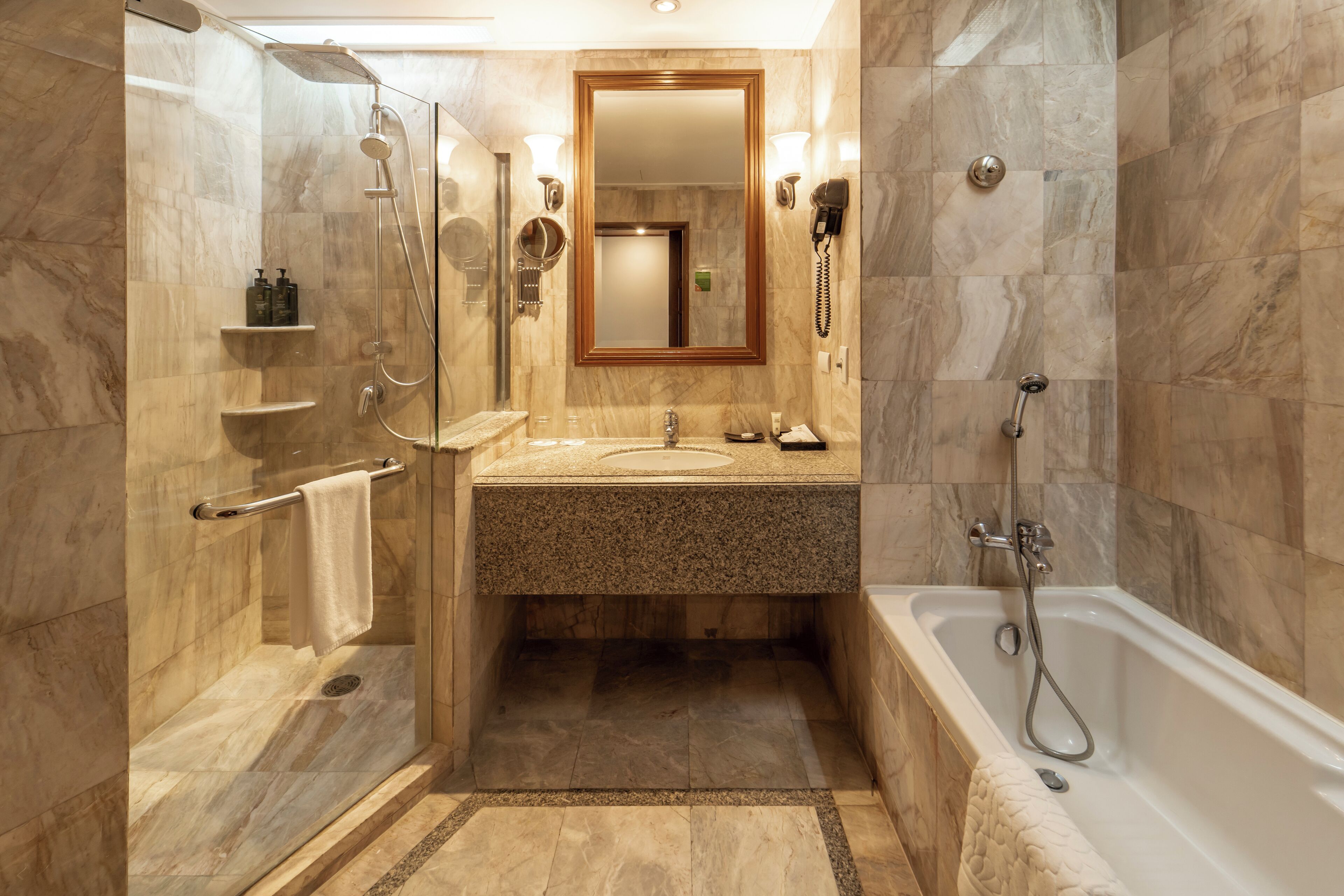 A modern bathroom with a glass-enclosed shower, a vanity with a sink and mirror, and a standalone bathtub.