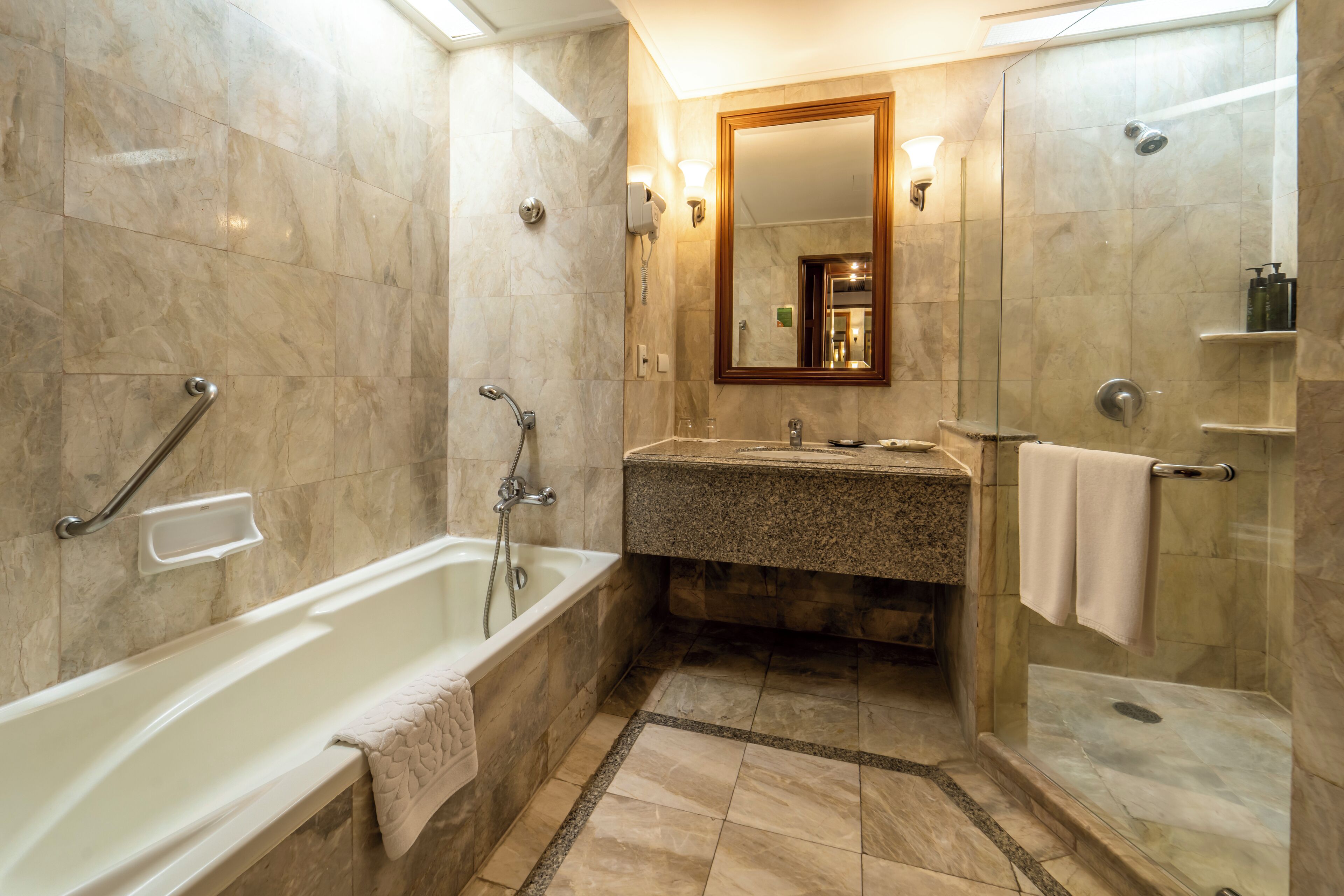 A bathroom with a bathtub, shower, and sink.