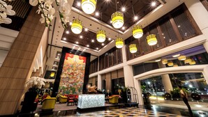 A hotel lobby with a reception desk, seating area, and large windows. - Century Park Hotel (Bangkok)