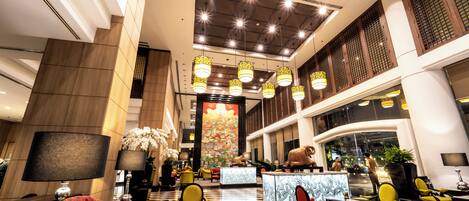 A spacious lobby with a reception desk, seating area, and a large decorative wall.