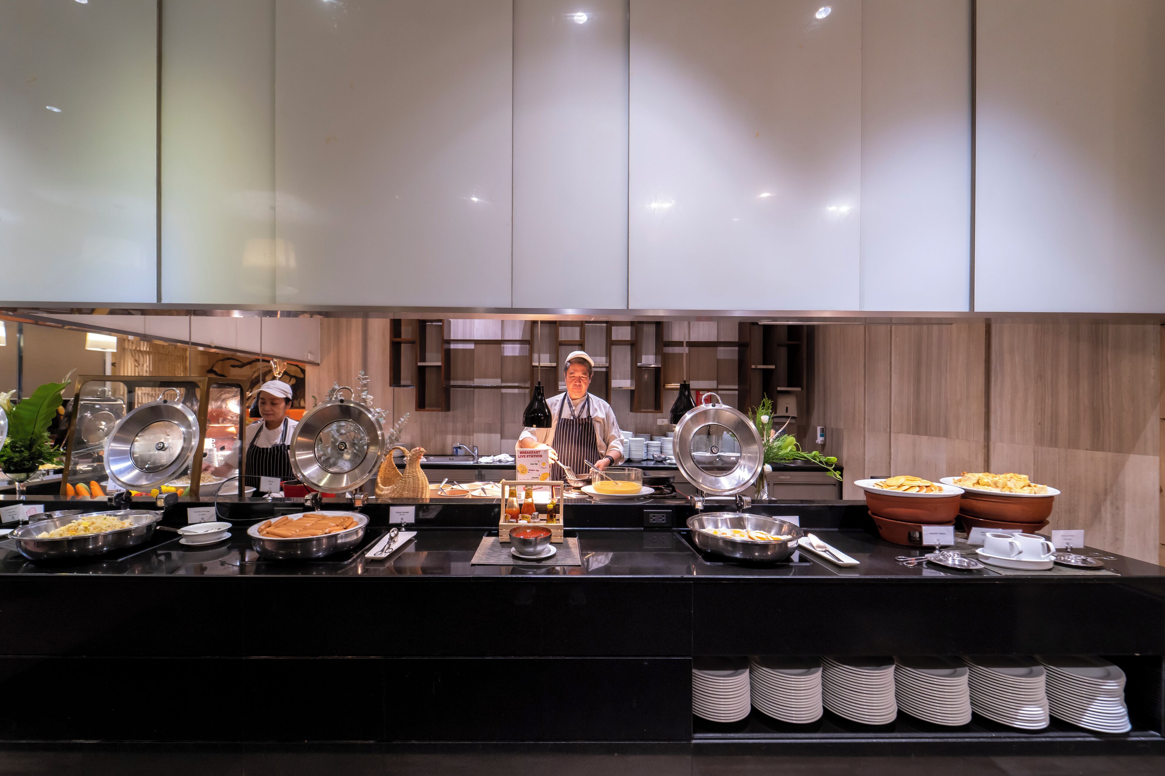 A buffet setup with various food items and a server.
