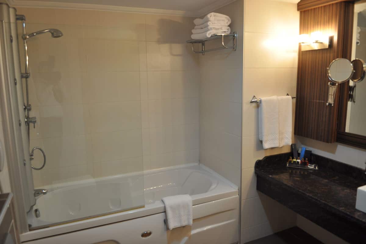 suite, 1 king bed | bathroom | combined shower/bathtub, hair dryer, slippers, towels