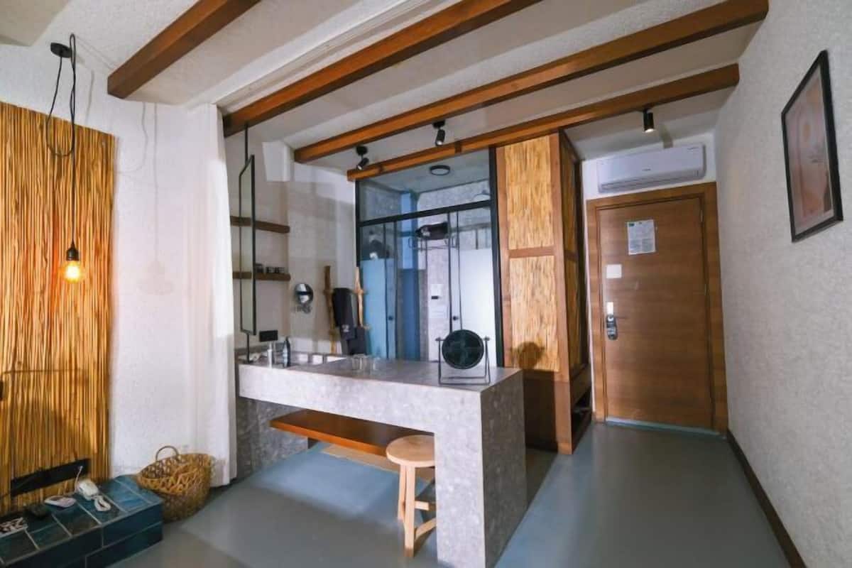 Une cuisine moderne dotée d’un plan de travail en marbre, de poutres en bois et d’un évier encastré.