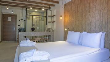 Una habitación de hotel con una cama grande, techo de madera, baño con espejo y barra para toallas.