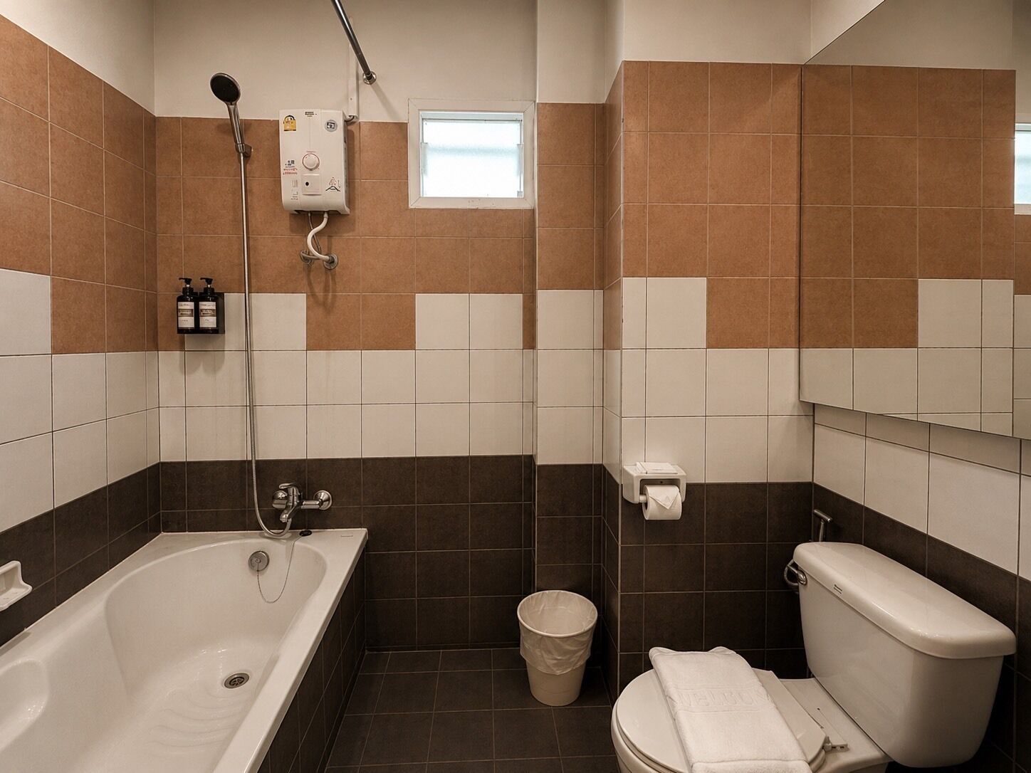 Un baño con bañera, inodoro, ducha y ventana.