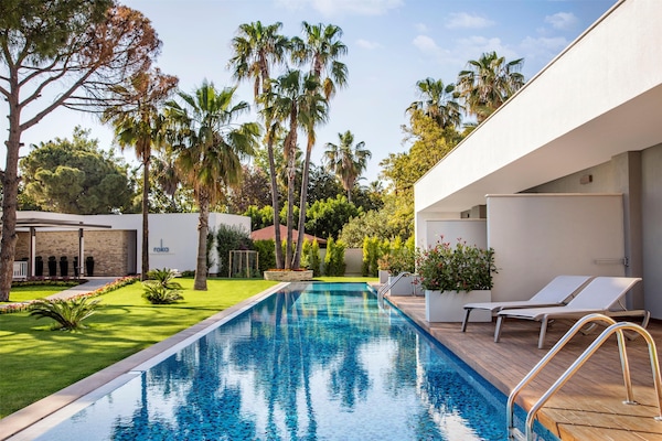 Una piscina techada, una piscina al aire libre de temporada, sombrillas