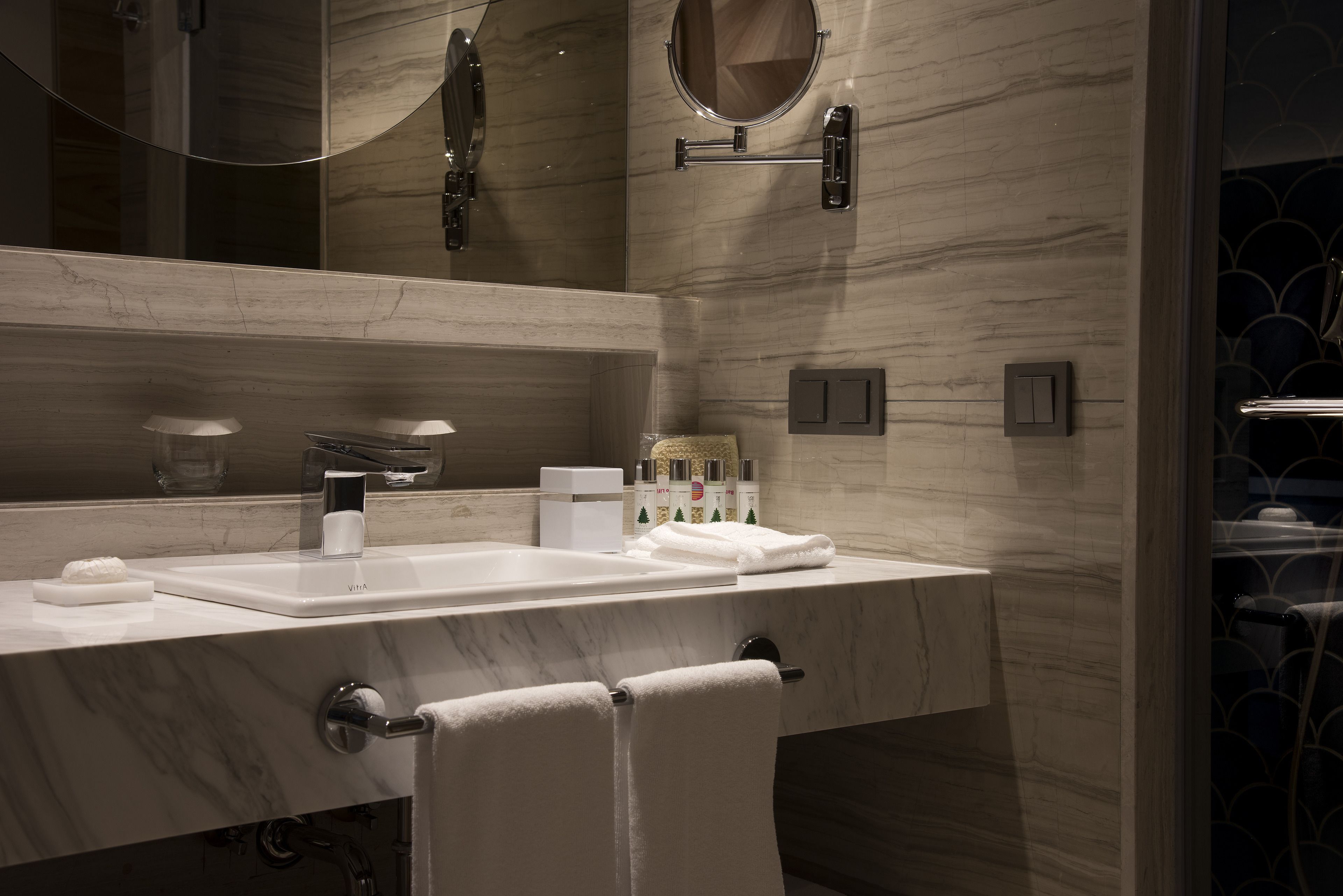 Un baño moderno con un espejo grande, un lavabo y un perchero para toallas.