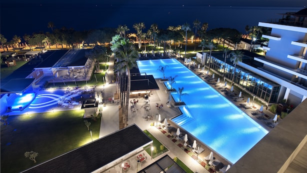 A resort with a large swimming pool, outdoor seating areas, and a view of the ocean. - Acanthus Cennet Barut Collection - Ultra All Inclusive (Manavgat)