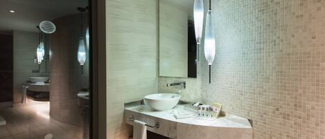 A modern bathroom with a large mirror, a white sink, and a glass shower enclosure.