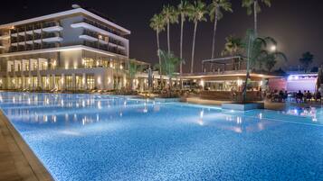 Una piscina con un hotel moderno al fondo.
