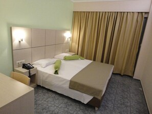 A hotel room with a bed, bedside table, and a telephone.