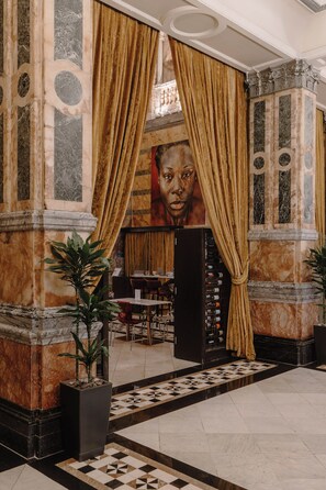 A lobby with marble columns, a checkered floor, and a large plant. - Club Quarters Hotel Trafalgar Square, London (London)