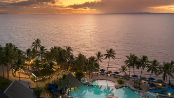 Alberca al aire libre, sombrillas en la alberca y camastros