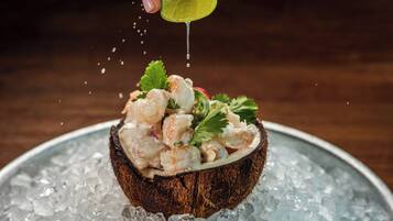 A shrimp salad in a coconut shell on ice.