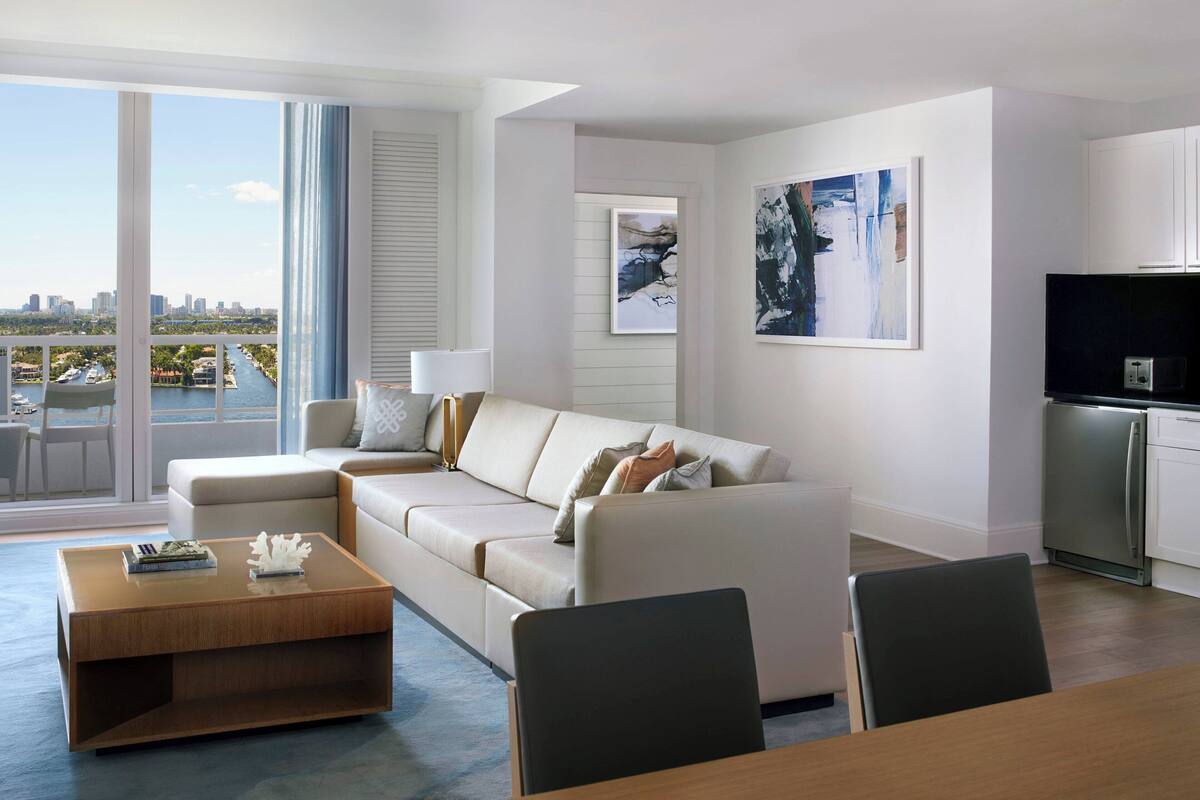 A modern living room with a sofa, coffee table, and dining area.
