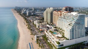 A coastal hotel with multiple high-rise buildings, a beach, and a marina.