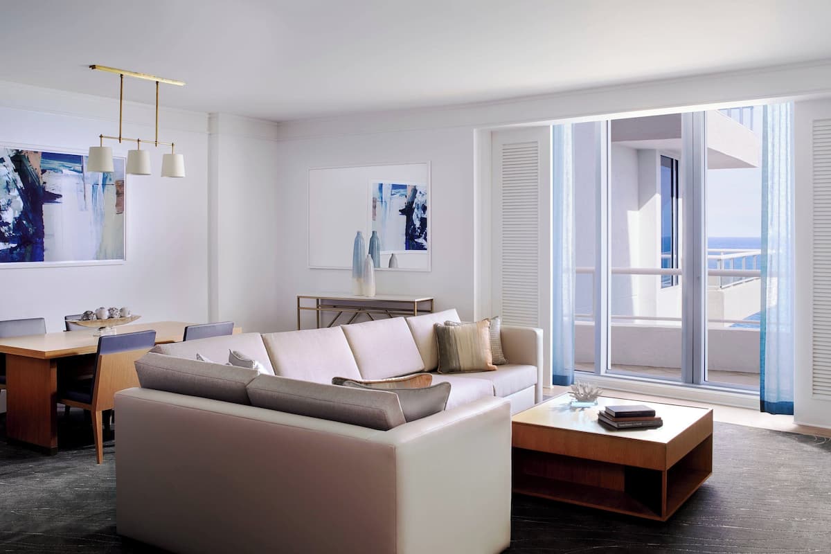 A modern living room with a sofa, coffee table, and dining area.