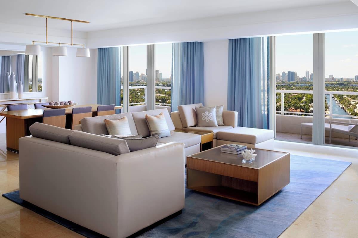 A modern living room with a sofa, coffee table, and dining area.
