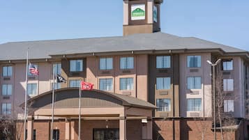 Hotel entrance with a curved overhang and a mix of brick and stucco architecture.
