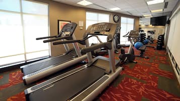 A hotel gym with treadmills, a stationary bike, and a rowing machine.