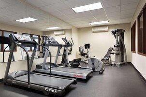 A gym with treadmills, elliptical machines, and a weight machine.