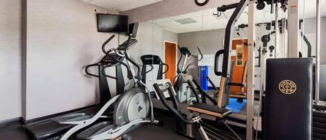 A gym with treadmills, elliptical machines, and weightlifting equipment.