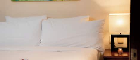 A neatly made bed with white linens, a book, and decorative items on the bed.