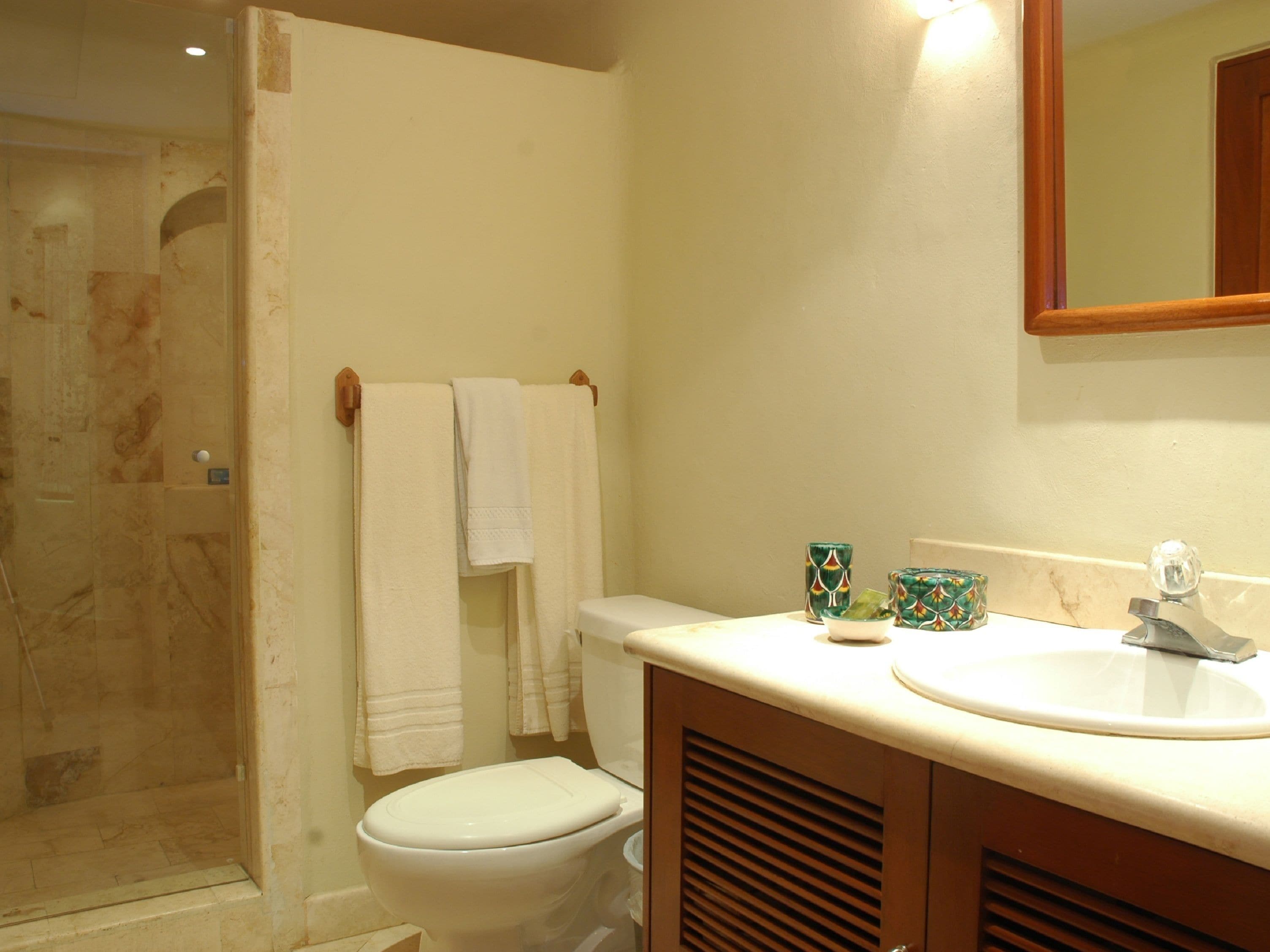 Un baño con inodoro, lavabo y ducha.