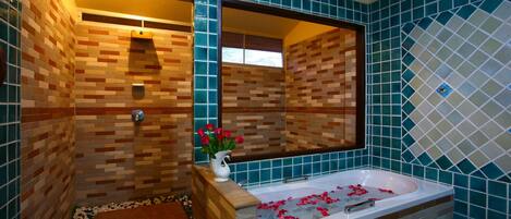Une salle de bain avec une baignoire, un espace douche et un miroir.